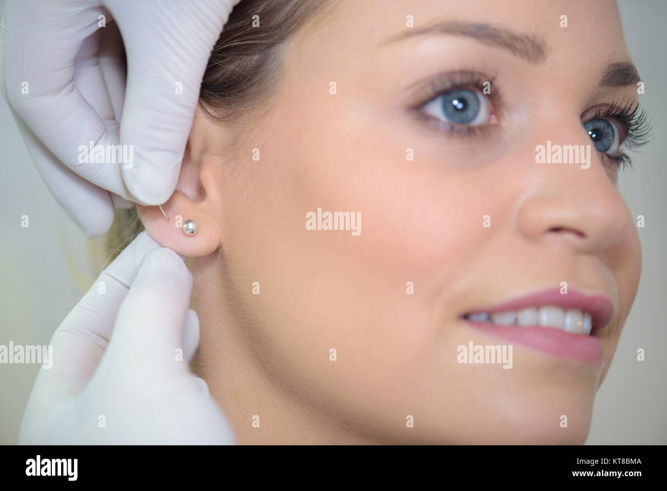 putting an extra earrings Stock Photo Alamy