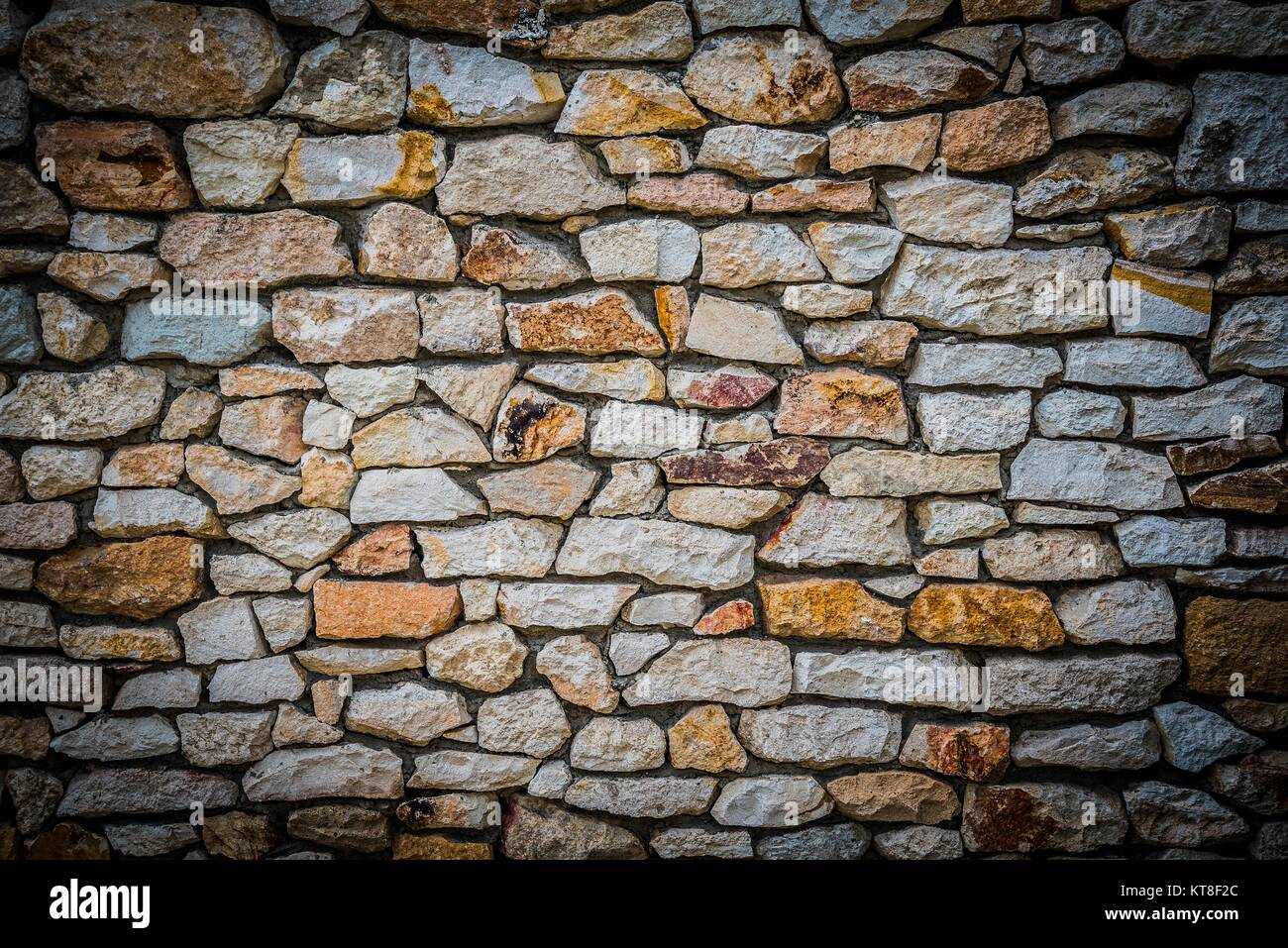 Stone wall background of colorful stones with HDR effect and vignetted borders Stock Photo