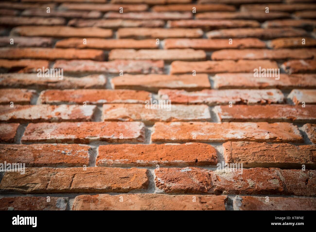 Red brick wall texture grunge background with vignetted corners in perspective view. Selective focus Stock Photo