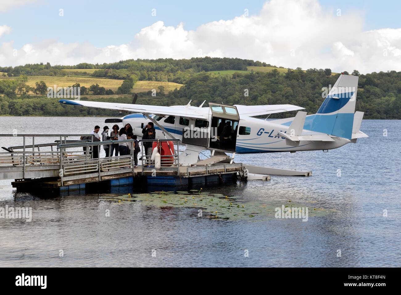 Passengers assemble on the jetty before boarding the floatplane on Loch Lomond, Alexandria, Scotland, UK Stock Photo