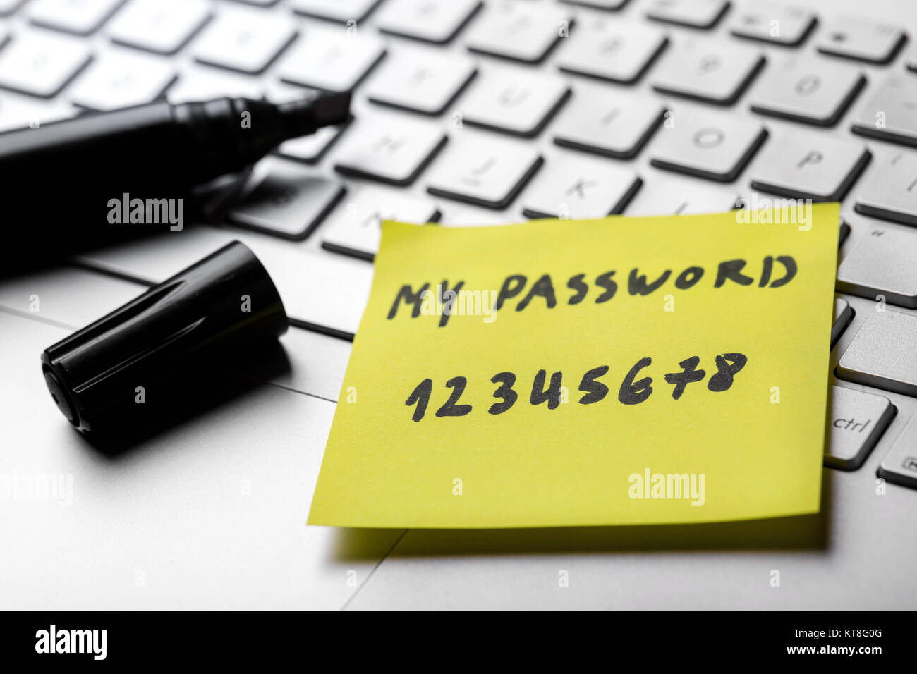 sticky note with weak easy password on laptop keyboard Stock Photo