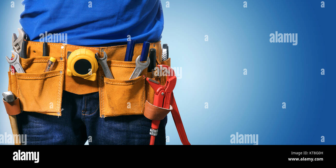 closeup of handyman tool belt on blue background with copy space Stock Photo