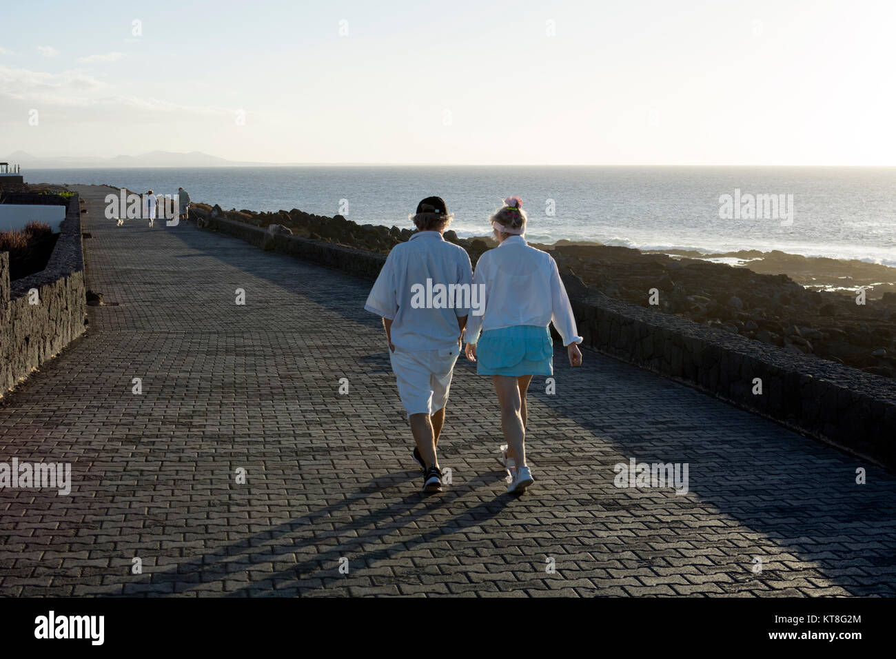 Couple walking along sea front, Playa Blanca, Lanzarote, Spain Stock Photo