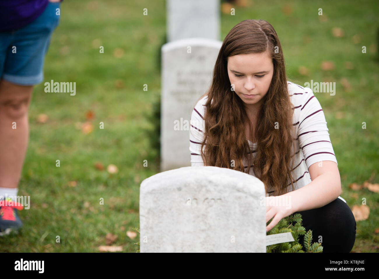 Katherine Johnson, 14, from Portland, Maine, places a wreath on a