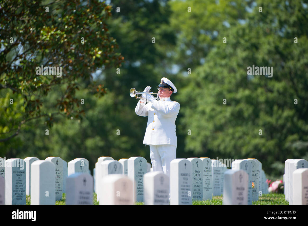 MU1 William Dunn, a bugler from the U.S. Navy Band, plays taps during the graveside service of U.S. Navy Petty Officer 1st Class Xavier A. Martin at Arlington National Cemetery, Arlington, Va., Aug. 9, 2017. Martin perished when the USS Fitzgerald (DDG 62) was involved in a collision with the Philippine-flagged merchant vessel ACX Crystal, flooding the berthing compartment he was occupying. Martin was buried with standard honors in Section 60. (U.S. Army photo by Elizabeth Fraser / Arlington National Cemetery / released) Stock Photo