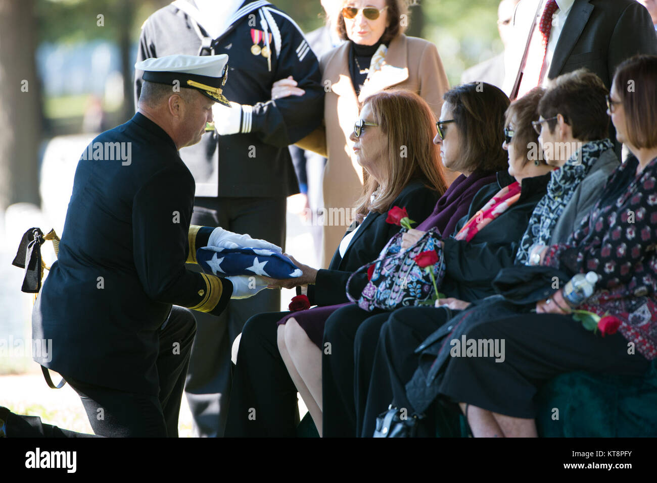 Katherine Kany receives the American flag during the graveside service for her uncle U.S. Navy Fireman 3rd Class John H. Lindsley, Oct. 25, 2016, in Section 60 of Arlington National Cemetery. Lindsley was assigned to the USS Oklahoma, which was moored at Ford Island, Pearl Harbor, when the ship was attacked by Japanese aircraft. The USS Oklahoma sustained multiple torpedo hits, which caused it to quickly capsize. The attack on the ship resulted in 429 casualties, including Lindsley. (U.S. Army photo by Rachel Larue/Arlington National Cemetery/released) Stock Photo