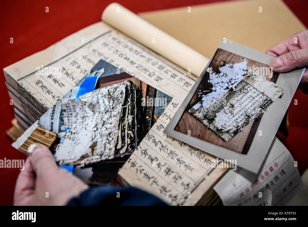 (171222) -- CHENGDU, Dec. 22, 2017 (Xinhua) -- Yuan Dongjue shows changes of ancient books before and after repair, in Sichuan Provincial Library in Chengdu, capital of southwest China's Sichuan Province, Dec. 21, 2017. Yuan Dongjue, a 70-year-old expert of ancient books repairs, has kept working on ancient book repair and conservation since 1983 in Ancient Books Repair Center of Sichuan Provincial Library. In her 34 years career time, Yuan has repaired about 200 valuable ancient Chinese books, some of them could date back to 1,000 years ago.  The repair work consists of over 10 different step Stock Photo