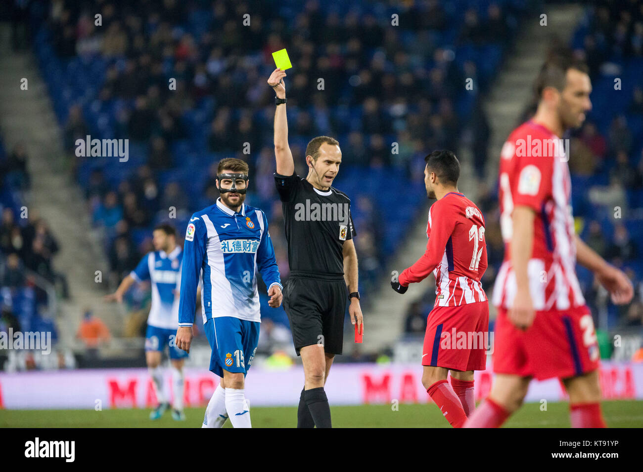 Barcelona, Spain. 23rd Dec, 2017. The referee shows the yellow card to Atlético Madrid midfielder Augusto Fernandez (12) during the match between RCD Espanyol v Atletico Madrid, for the round 17 of the Liga Santander, played at RCDE Stadium on 23th December 2017 in Barcelona, Spain. (Credit: GTO/Urbanandsport/Gtres Online) Credit: Gtres Información más Comuniación on line, S.L./Alamy Live News Stock Photo