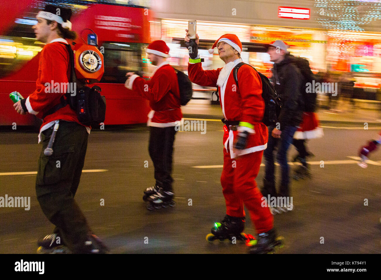 London, UK. 23rd Dec, 2017. A horde of rollerblading Santas skate down Oxford Street as shoppers crowd London on the second last shopping days before Christmas. Credit: Paul Davey/Alamy Live News Stock Photo