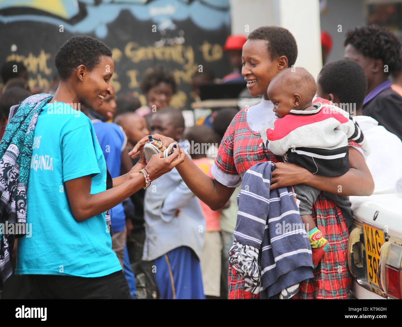 Nairobi, Kenya. 22nd Dec, 2017. Some of Kororgocho slum dwellers in Nairobi hold baby's shoes donated through an initiative dubbed ''˜Mng'aro Mtaani' ahead of Christmas celebration where people across the city give out clothing they don't use to the less fortunate. Initiative's founder Mr. Sam Omoll ''“ Torez who grew up in the slum said over 60,000 people living in Korogocho lack basic needs among them shelter, clothing, clean water and food. Majority survive on less than 1 USD a day, experience high crime rate, lack good education and health facilities. (Credit Image: © Billy Stock Photo