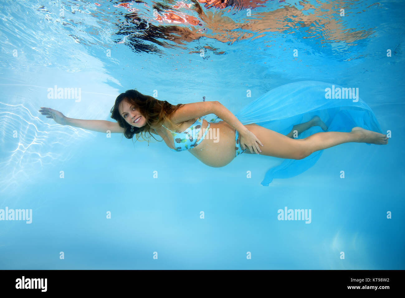 Young pregnant woman in a bikini under water in the pool Stock Photo