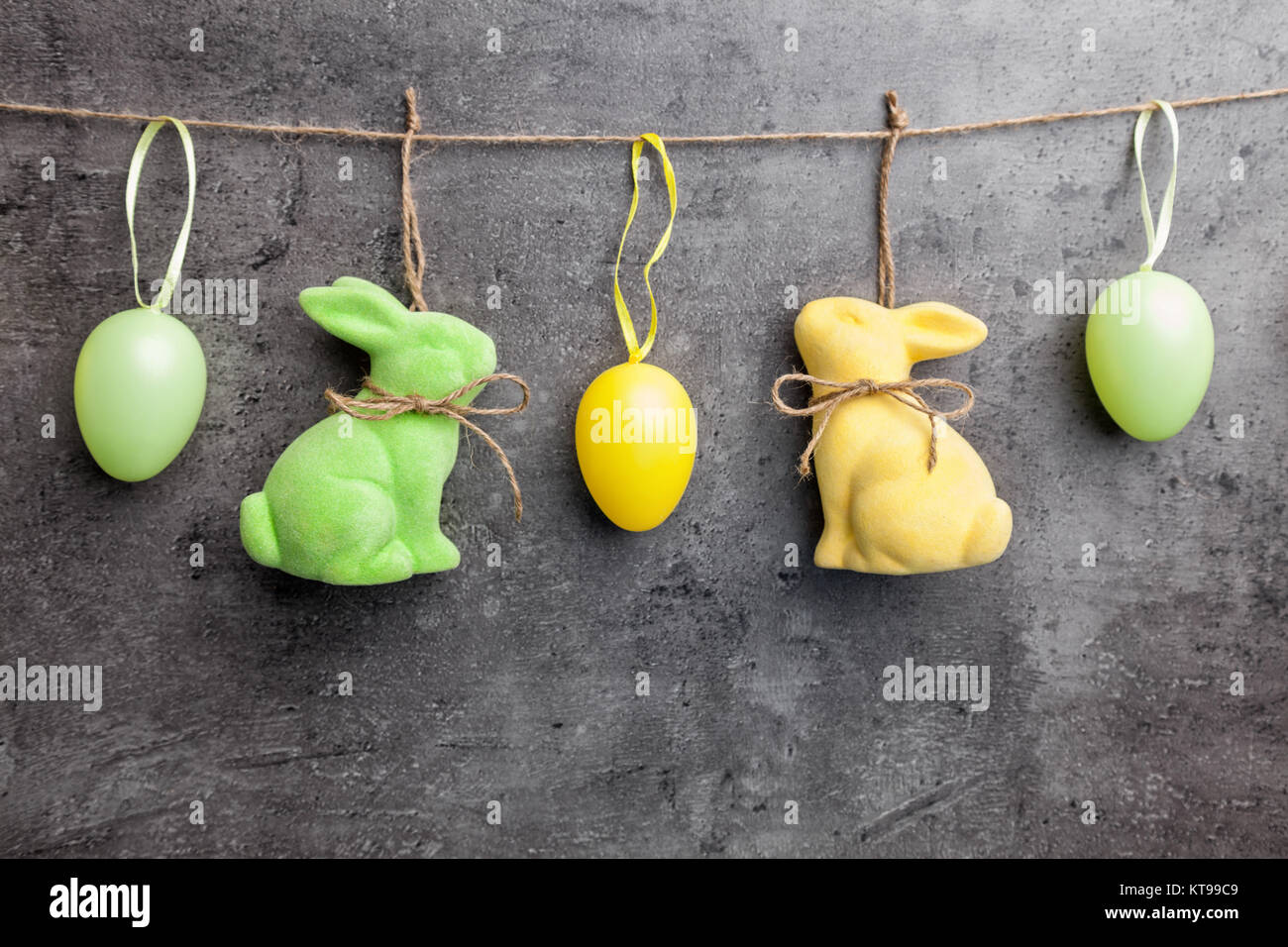 Easter eggs and bunnies on hanging on rustic background Stock Photo - Alamy