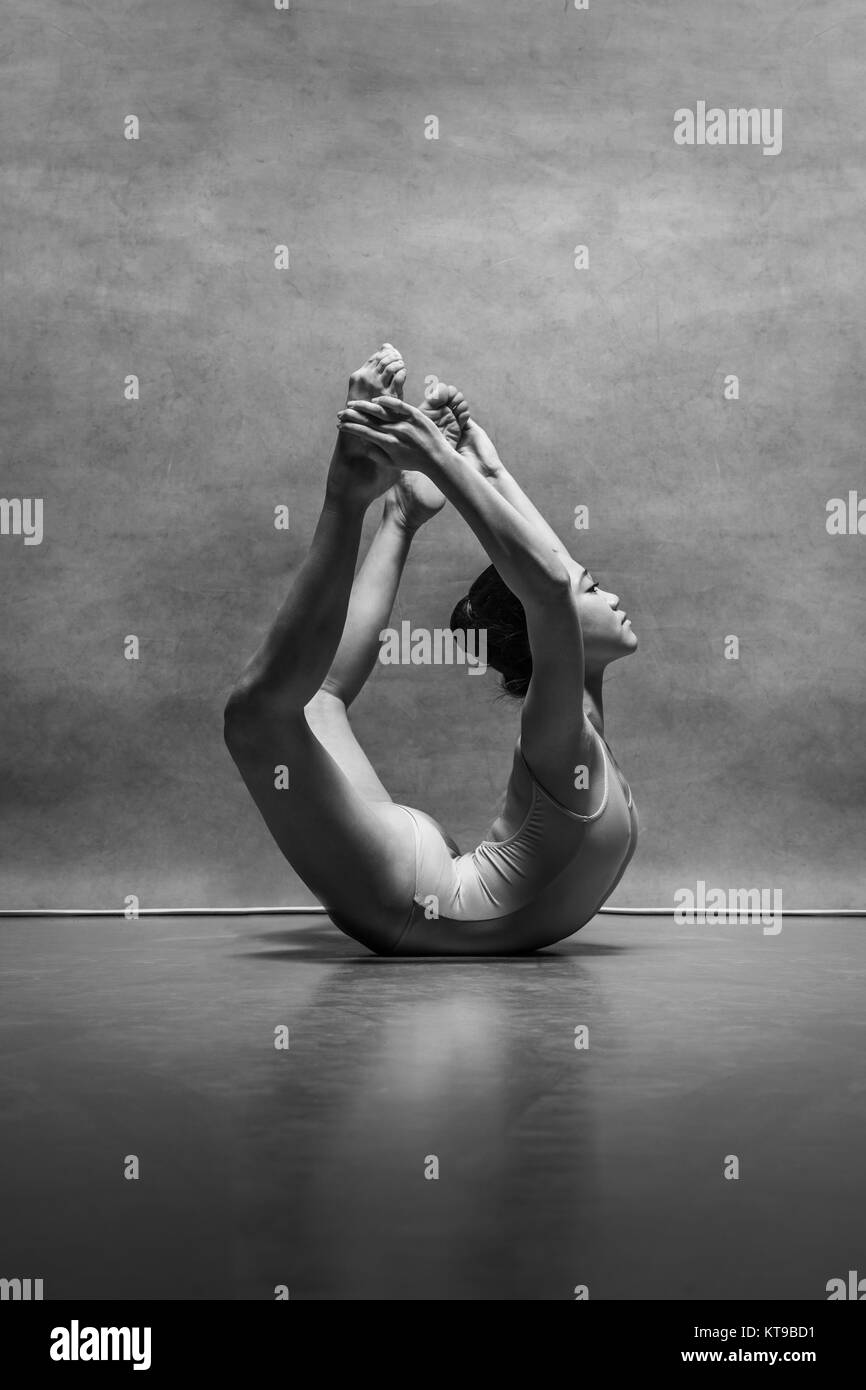 The female ballet dancer posing over gray background Stock Photo