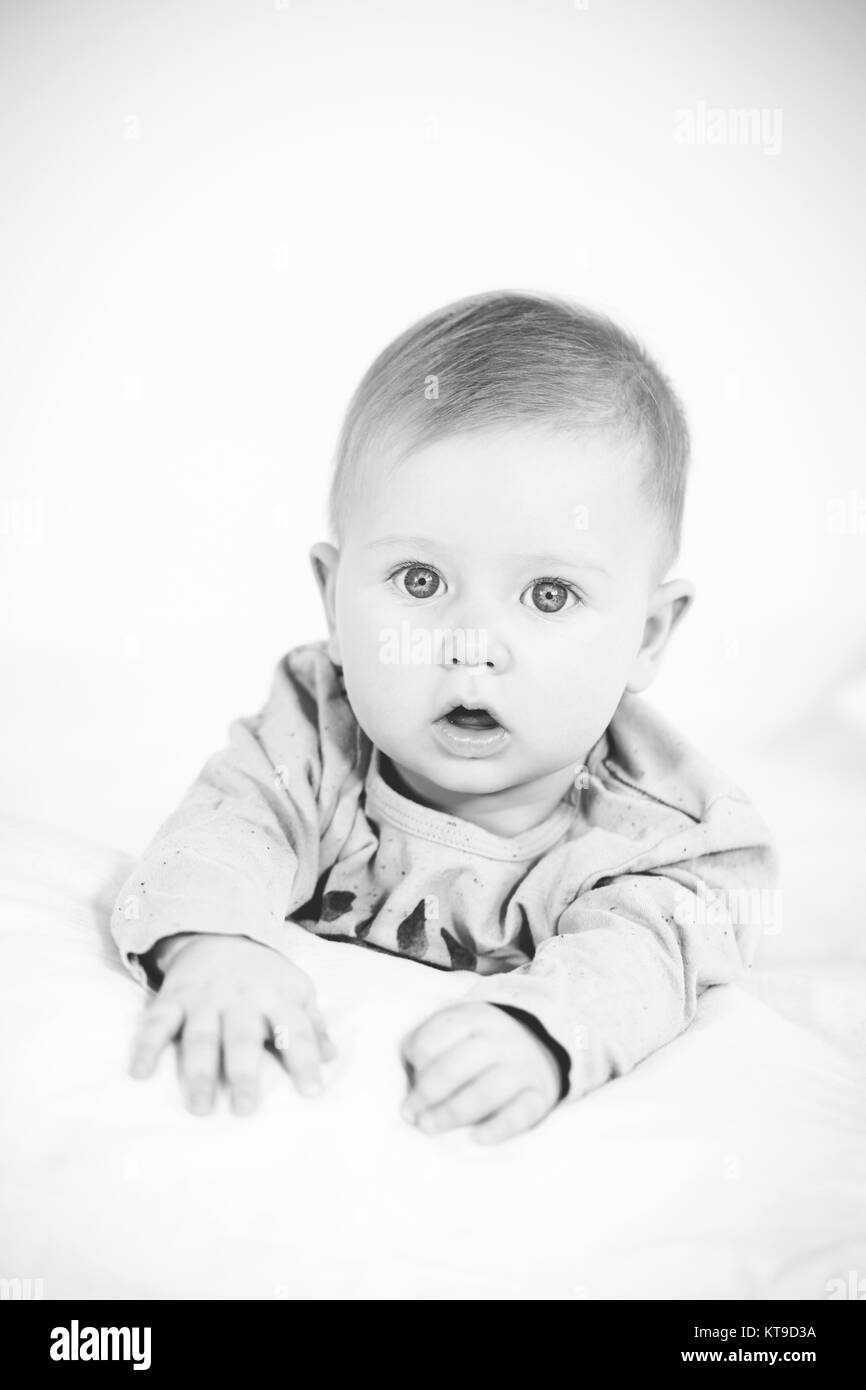 beautiful baby boy lying in bed on white background Stock Photo