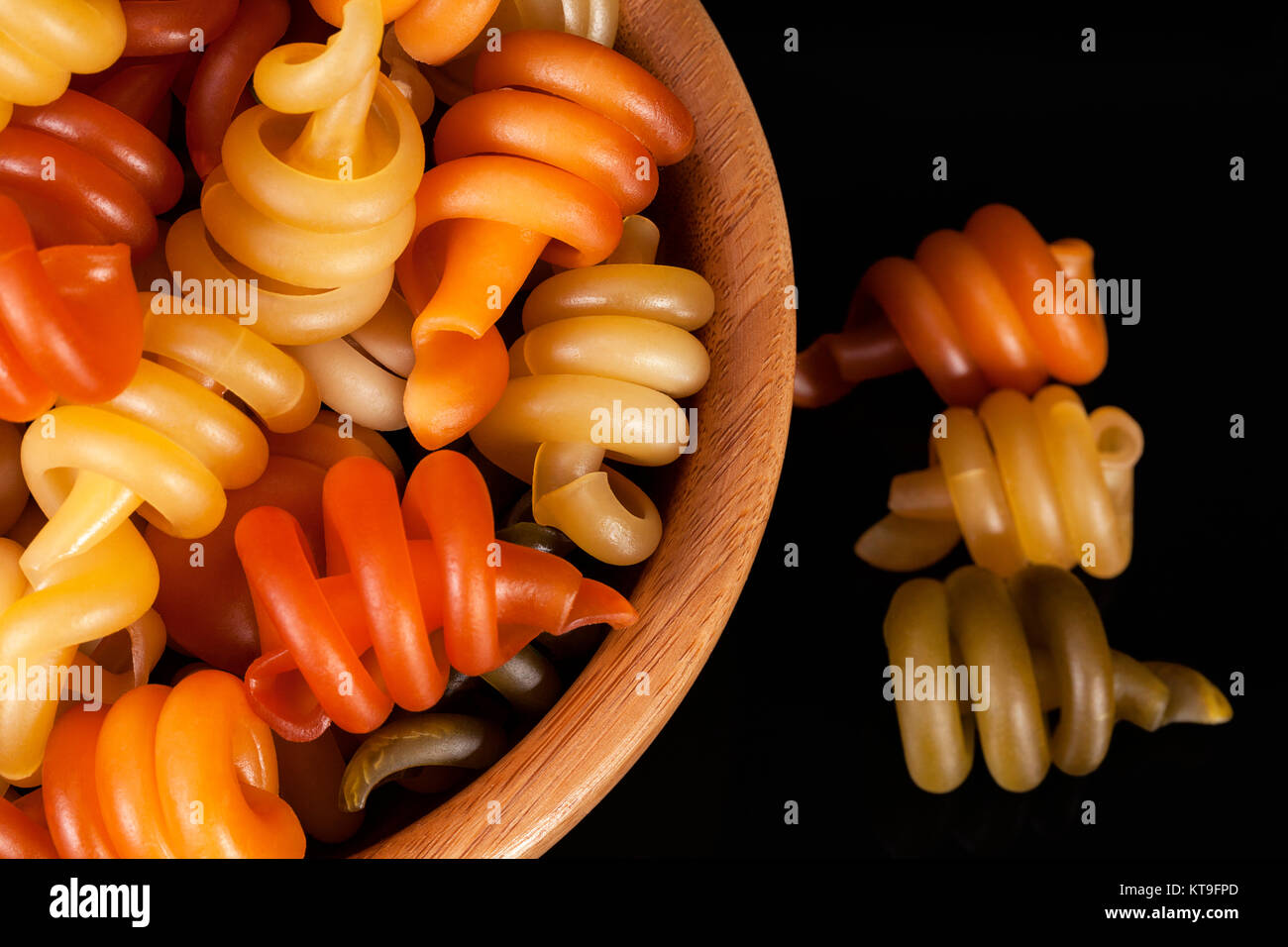 Spiral pasta trottole tricolore isolated in wooden bowl on black ...