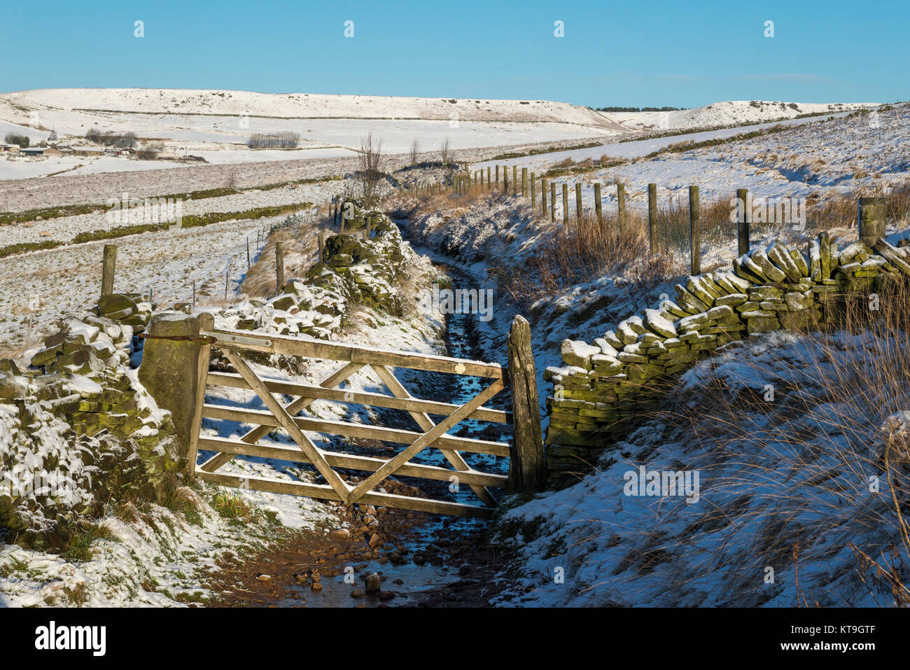 Old wooden gate on a footpath near Rowarth, Derbyshire, England on a snowy winter morning. Stock Photo