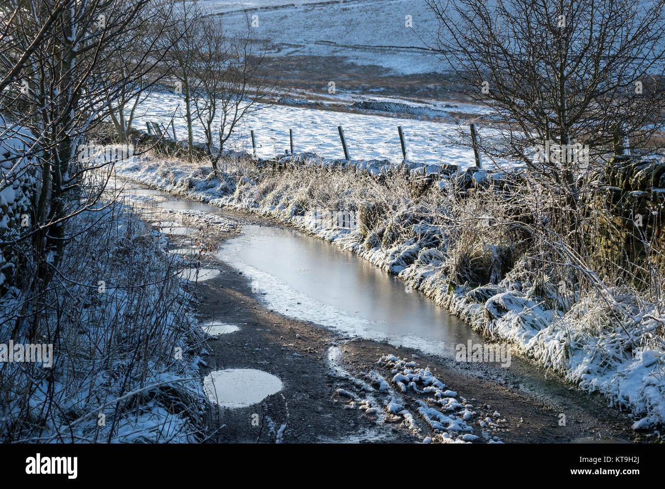 Icy country track in the hills of the Peak District on a frosty December morning. Rowarth, Derbyshire, England. Stock Photo