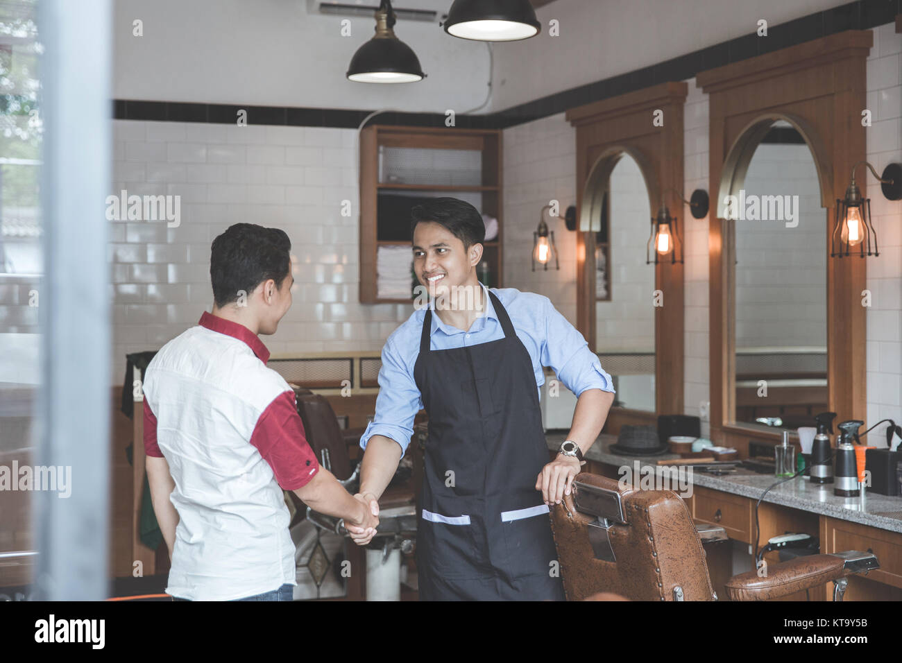 Handshake at barber and his client shaking hands while