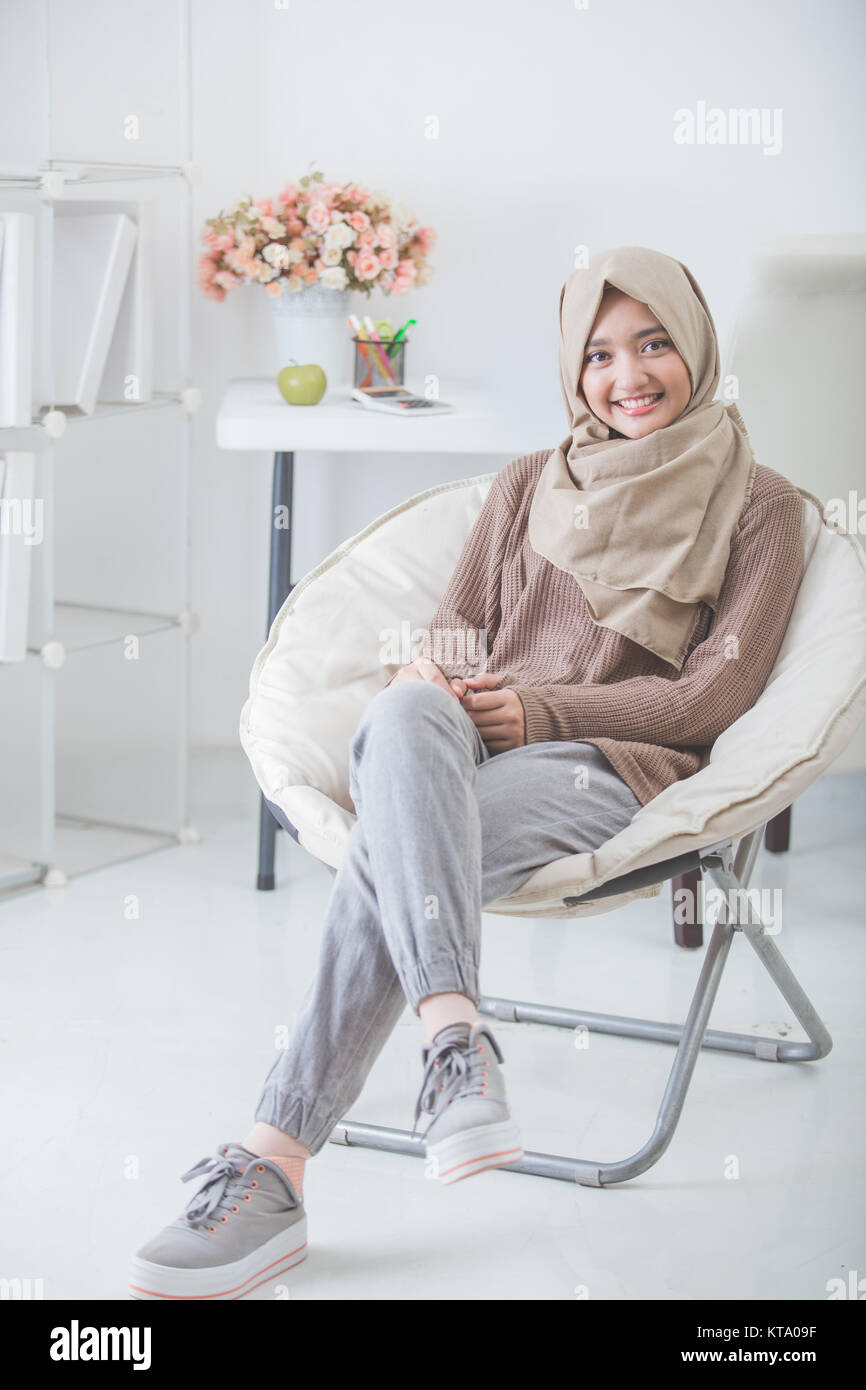 portrait of attractive young woman with hijab smiling to camera while ...