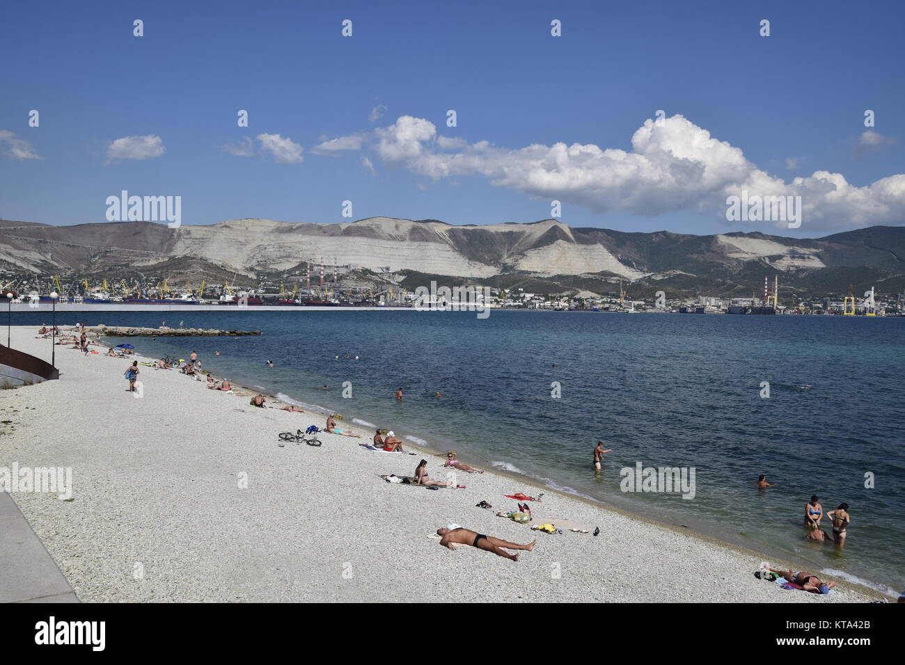 City beach town of Novorossiysk. Cargo port with port cranes. Sea bay and mountainous coast. Stock Photo