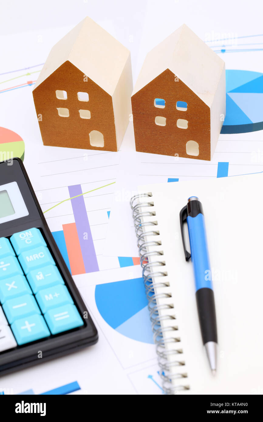 Miniature model of house on chart printed documents, notebook and pen Stock Photo