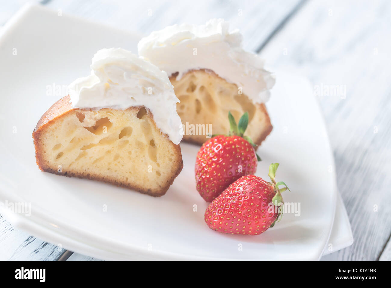 Rum baba decorated with whipped cream on the plate Stock Photo Alamy