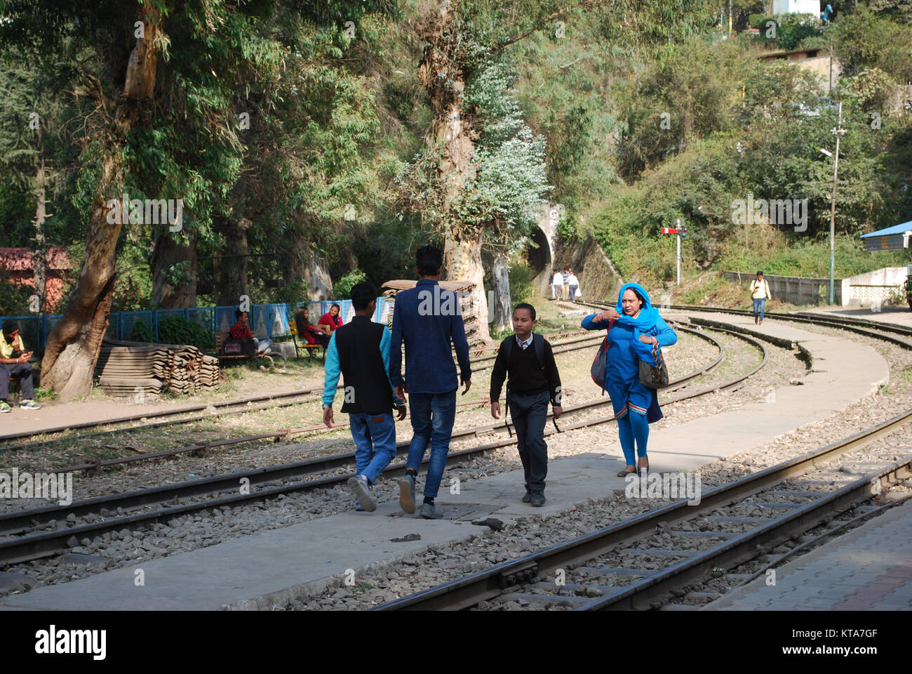 people walking on the train tracks at Solan railway station part of the Kalka - Shimla Railway line in North India Stock Photo