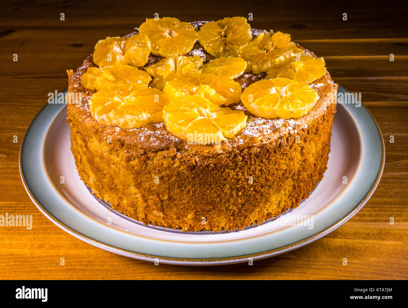 An appetising, freshly baked, spiced almond and sliced orange (clementines) cake, sitting on a ceramic plate. England, UK. Stock Photo