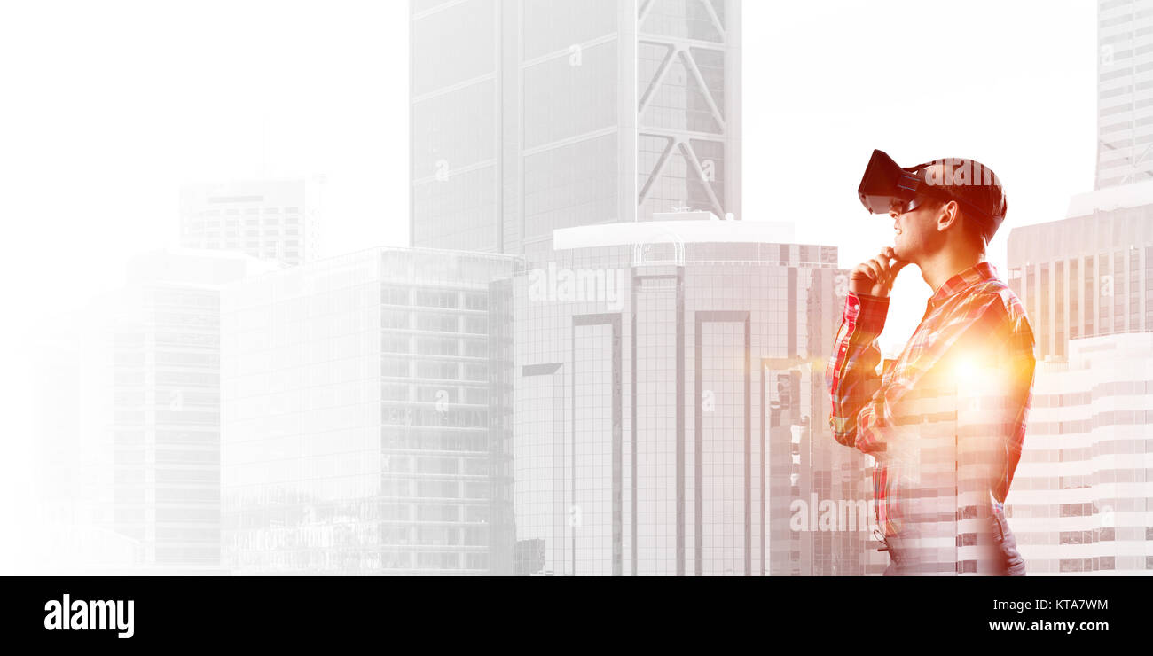 Young man with virtual reality headset or 3d glasses over cityscape ...