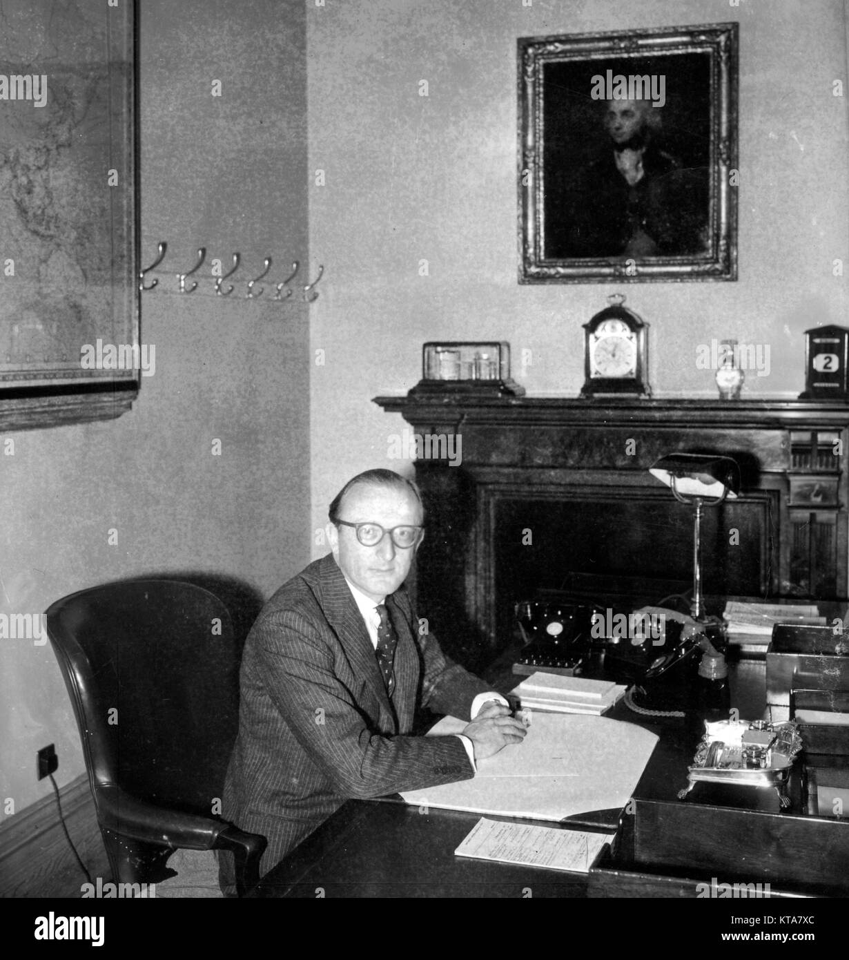 Lord Carrington, 40, the First Lord of the Admiralty, sat beneath a picture of Lord Nelson at his desk at the Admiralty, Whitehall, London. *Neg corrupt. Contact scanned Stock Photo