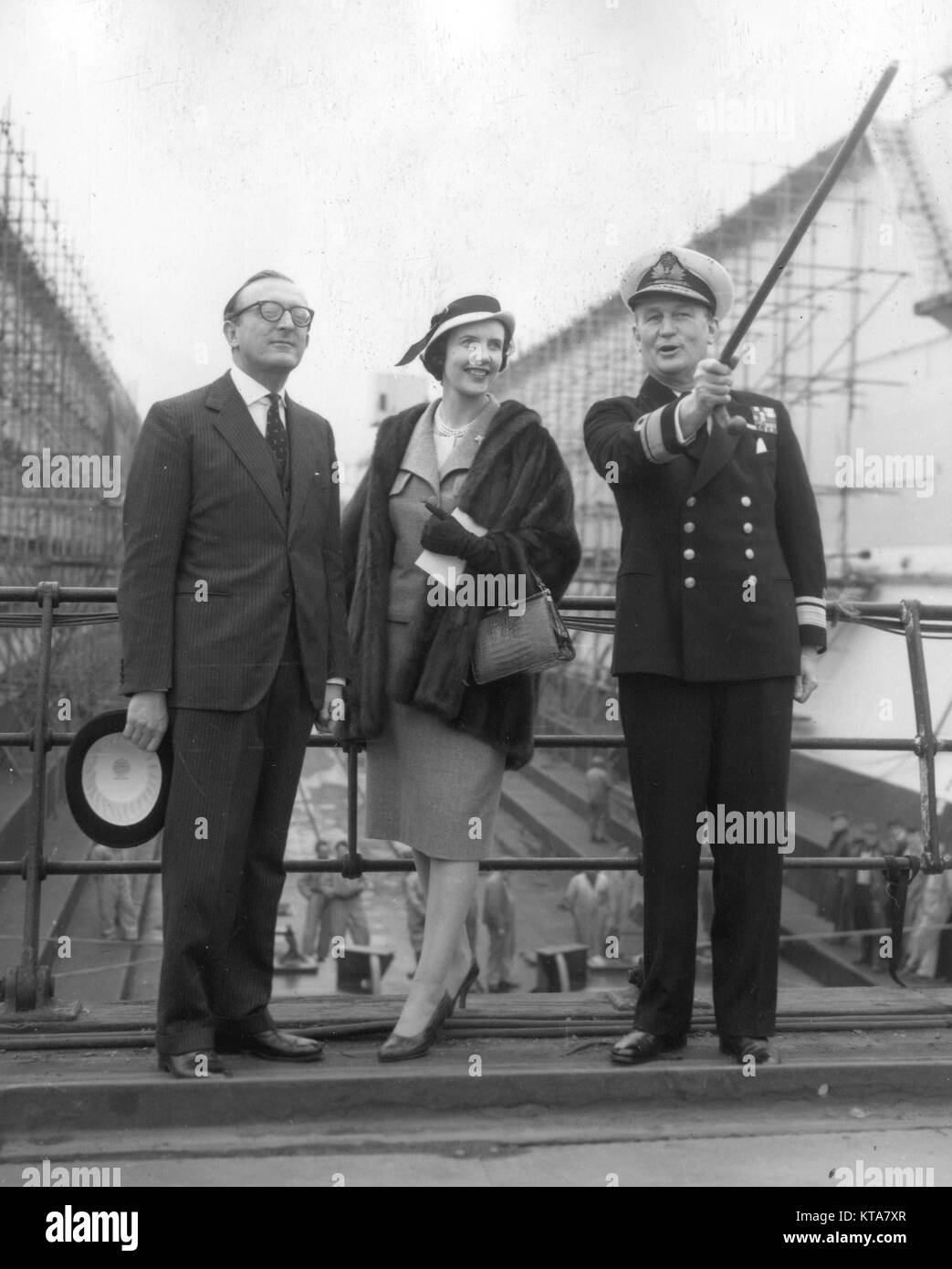 Lord Carrington, First Lord of the Admiralty, and Lady Carrington with Rear-Admiral J.H. Unwin (with stick), Adirmal Superintendent of Portsmouth Dockyard, inspect Admiralty Floating Dock No.59, which was launched by Lady Carrington in the dockyard earlier in the day. *Neg corrupt. Contact scanned Stock Photo