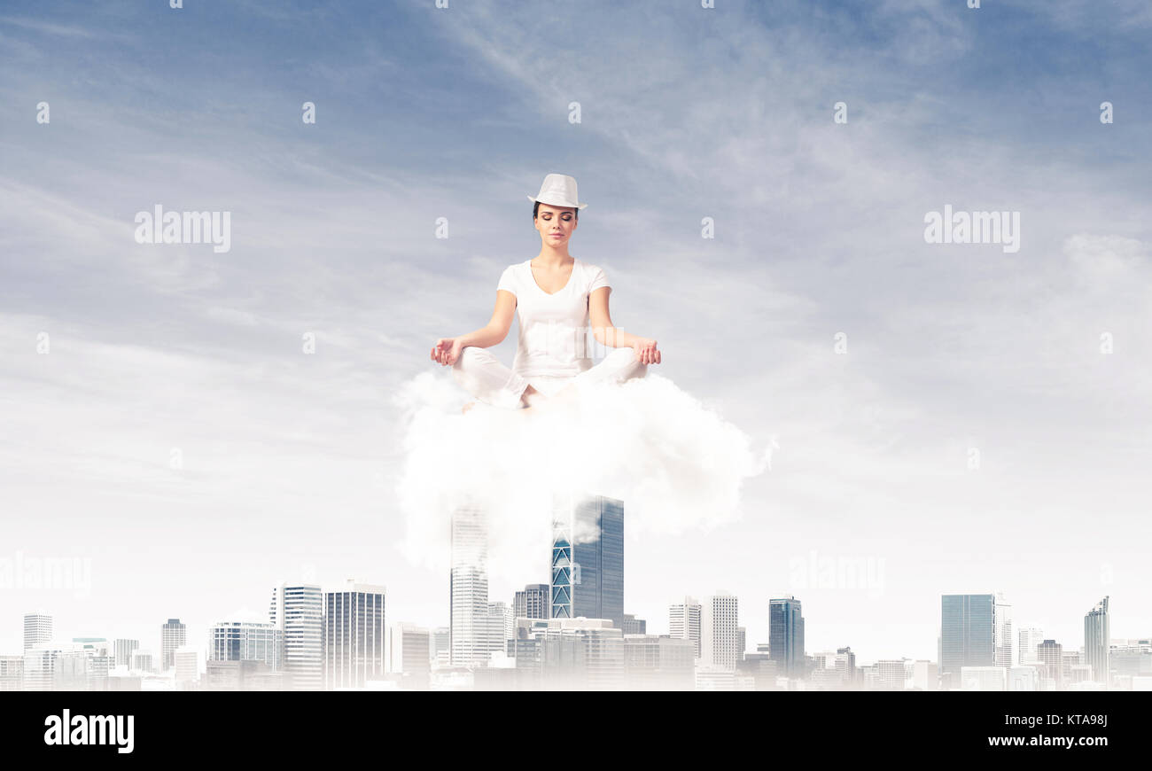 Woman in white clothing keeping eyes closed and looking concentrated ...