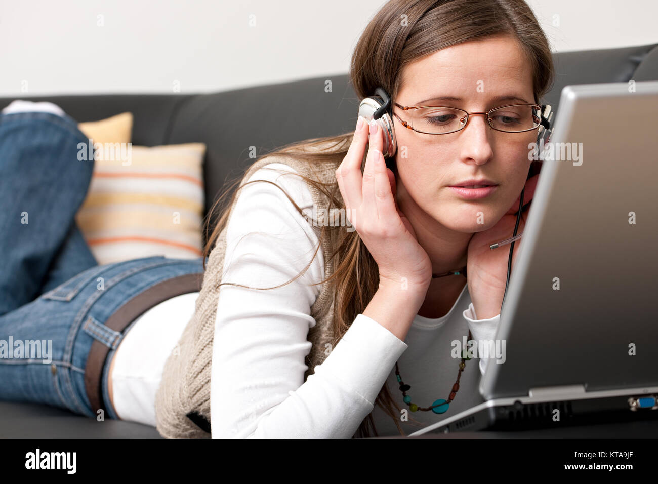 Pretty young woman is working on a laptop in her living room Stock ...
