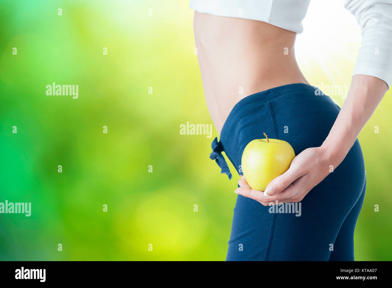 Woman showing an apples in close up of belly stomach Stock Photo Alamy