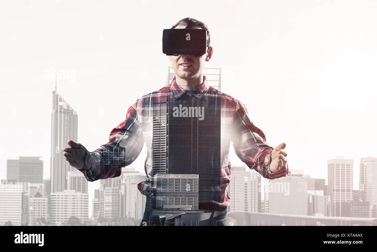 Young man with virtual reality headset or 3d glasses over cityscape ...