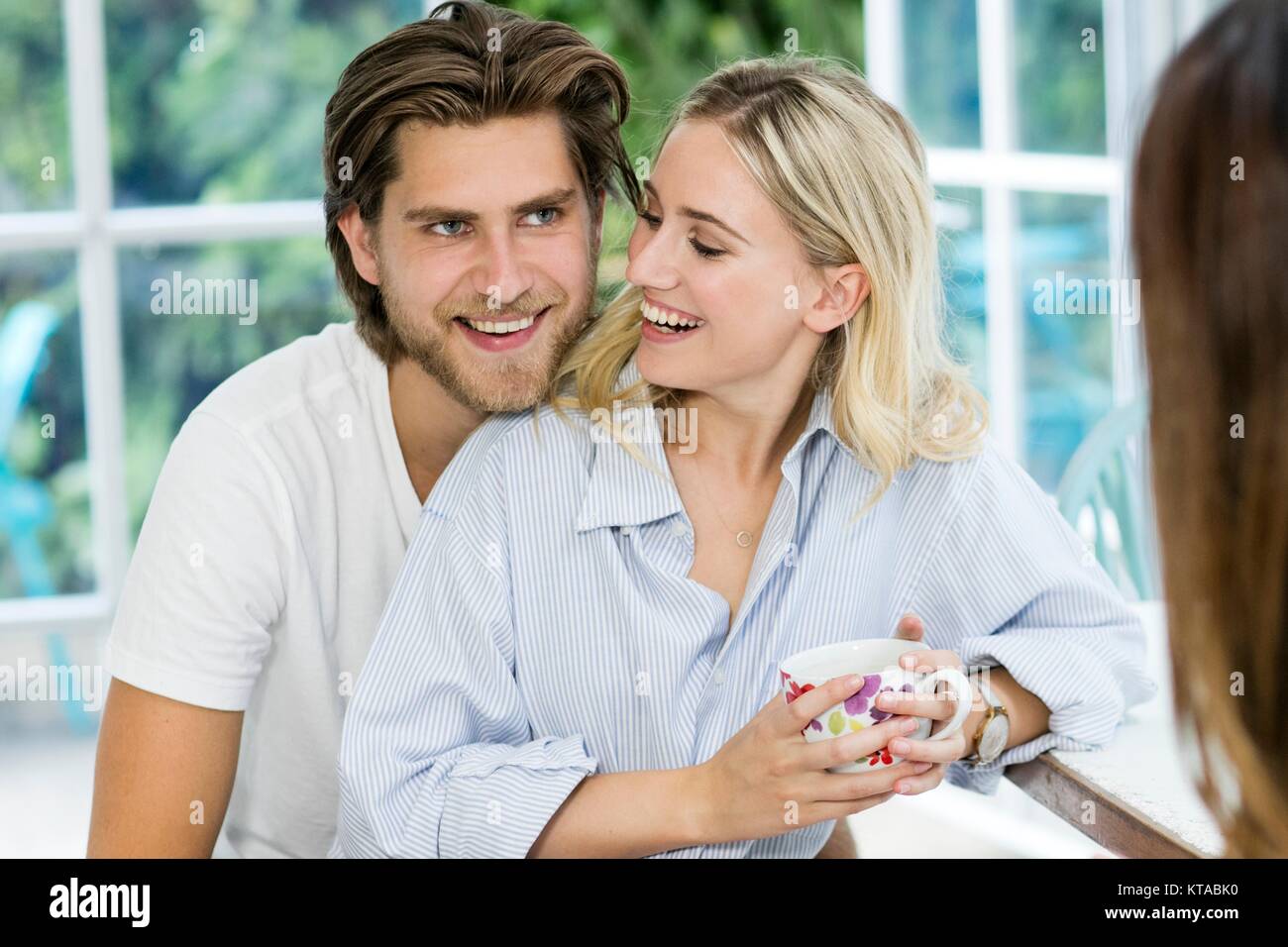 Young couple in kitchen, smiling. Stock Photo