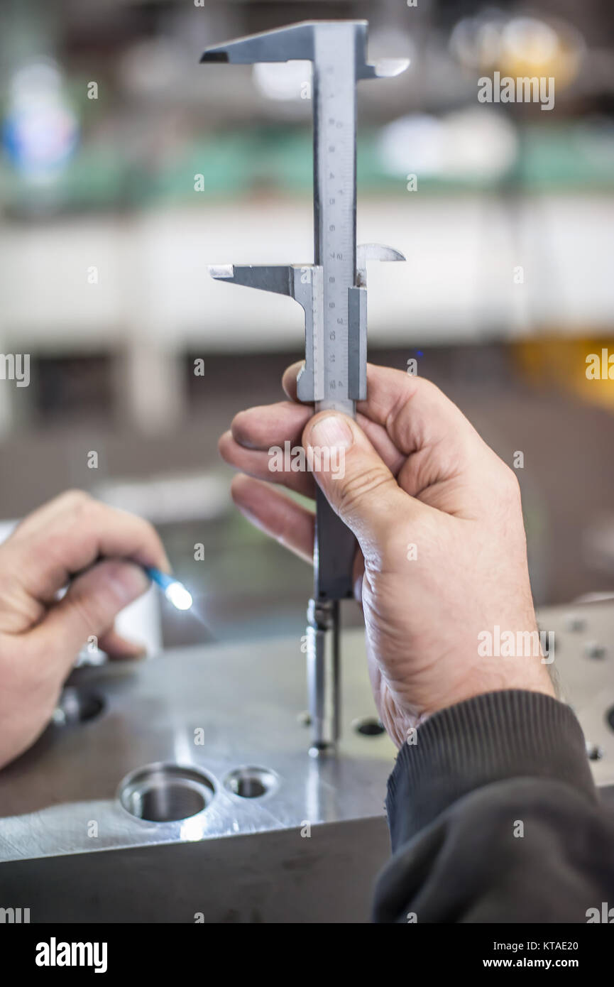 Repairer using accurate ruler for measuring in workshop. Close up Stock ...