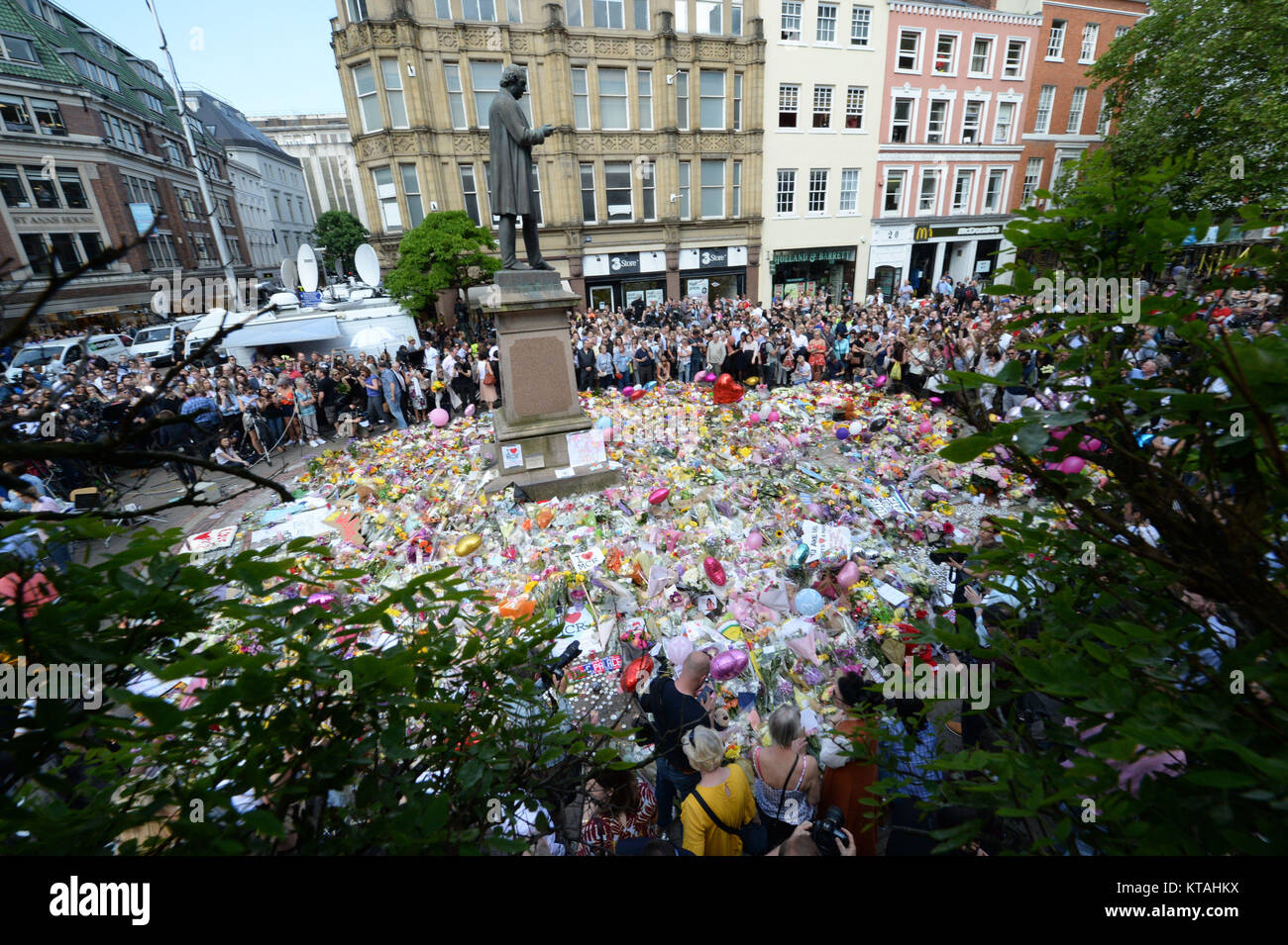 Review of the Year 2017: May: Crowds look at the floral tributes after a minute's silence in St Ann's Square, Manchester, to remember the victims of the terror attack at the Manchester Arena during an Ariana Grande gig earlier that week. Stock Photo