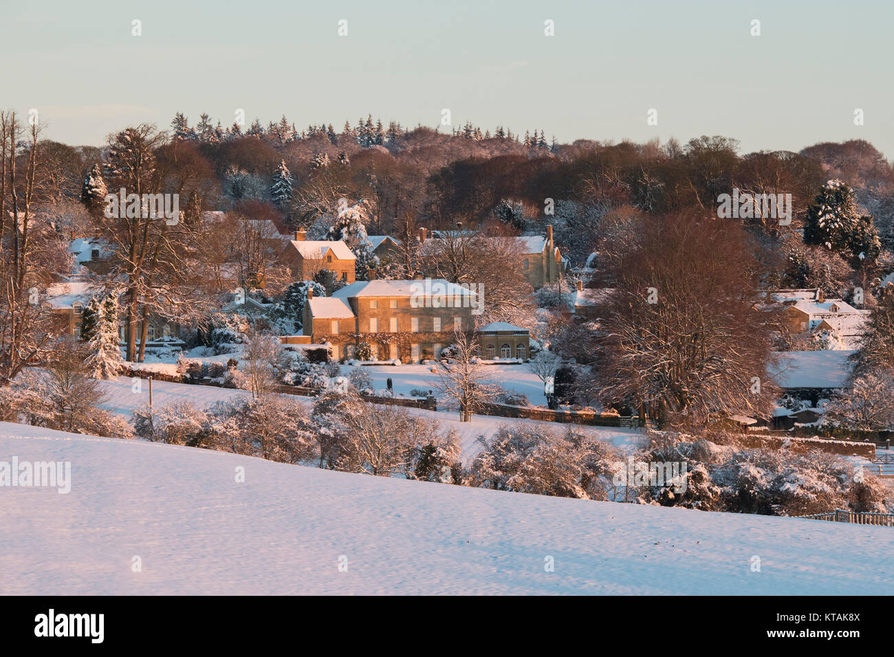 Bourton on the Hill manor house in the snow at sunrise in December. Bourton on the Hill, Cotswolds, Gloucestershire, England. Stock Photo