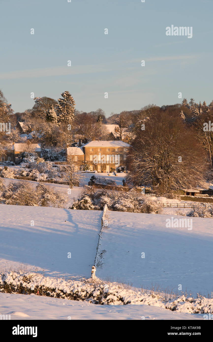 Bourton on the Hill manor house in the snow at sunrise in December. Bourton on the Hill, Cotswolds, Gloucestershire, England. Stock Photo