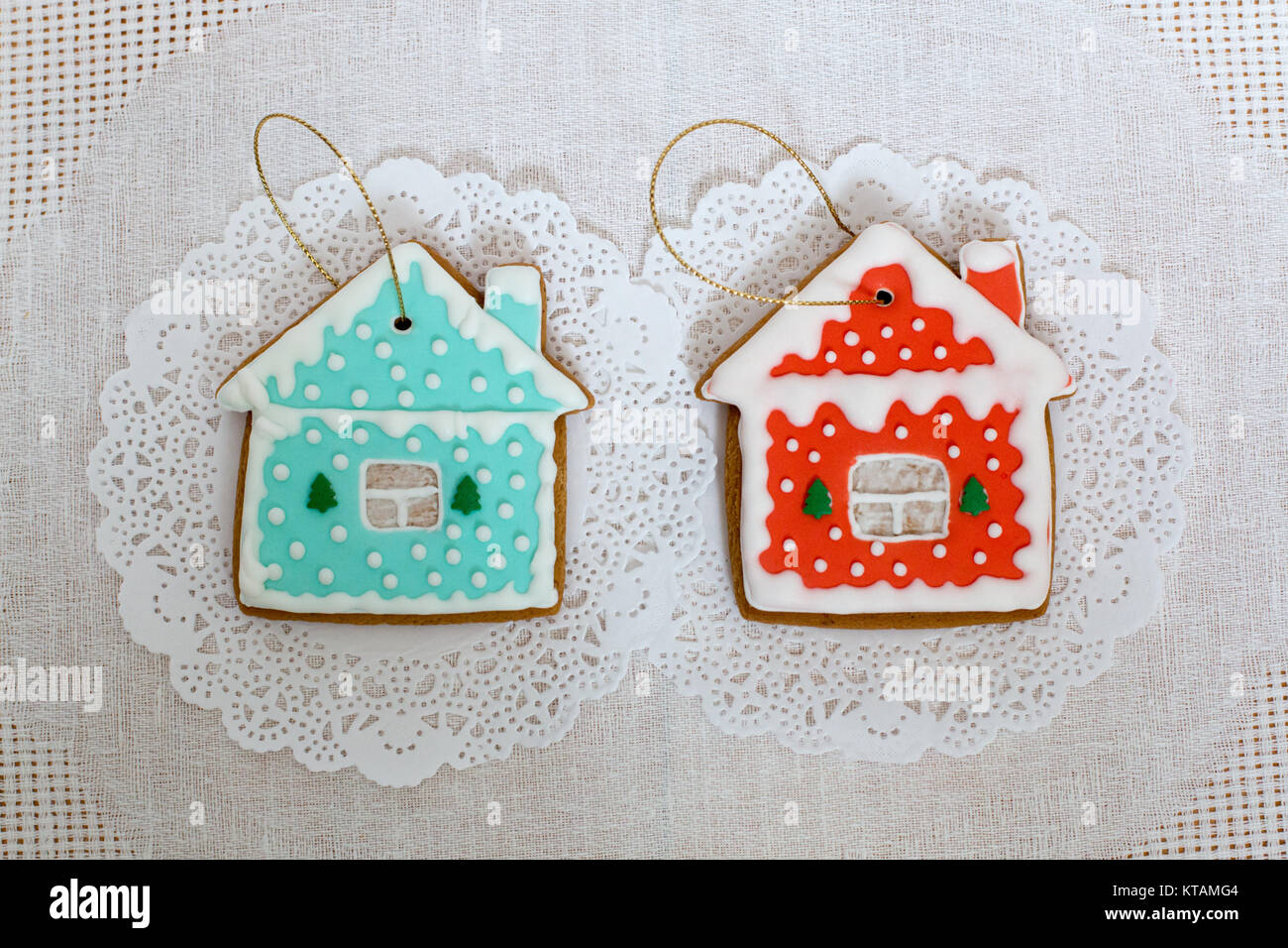 Two gingerbread cookies in the shape of the small cottage on a white ...