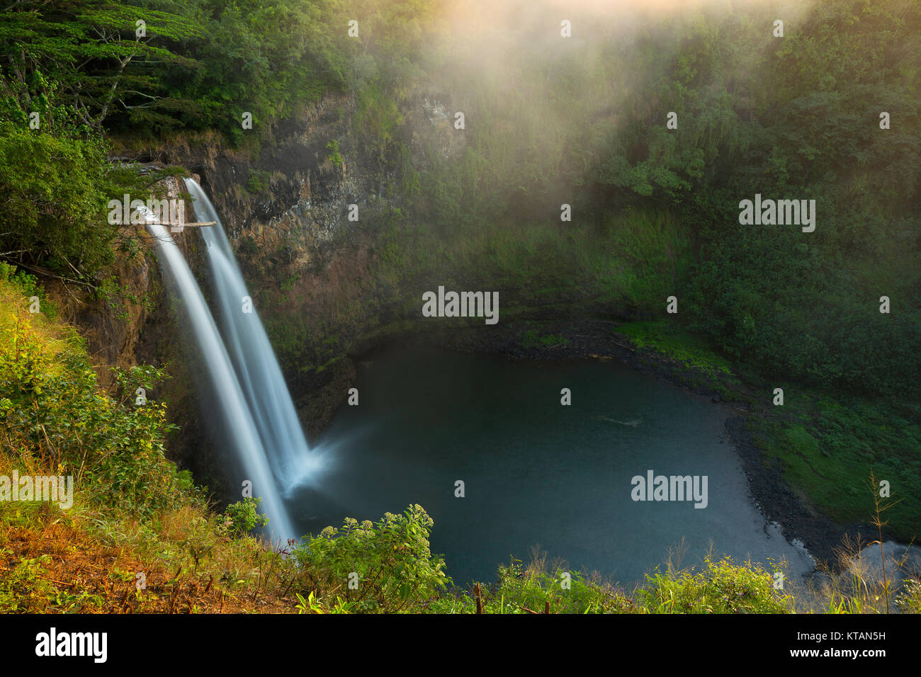 Wailua Falls in the mist at sunrise in the island of Kauai, Hawaii. USA Stock Photo