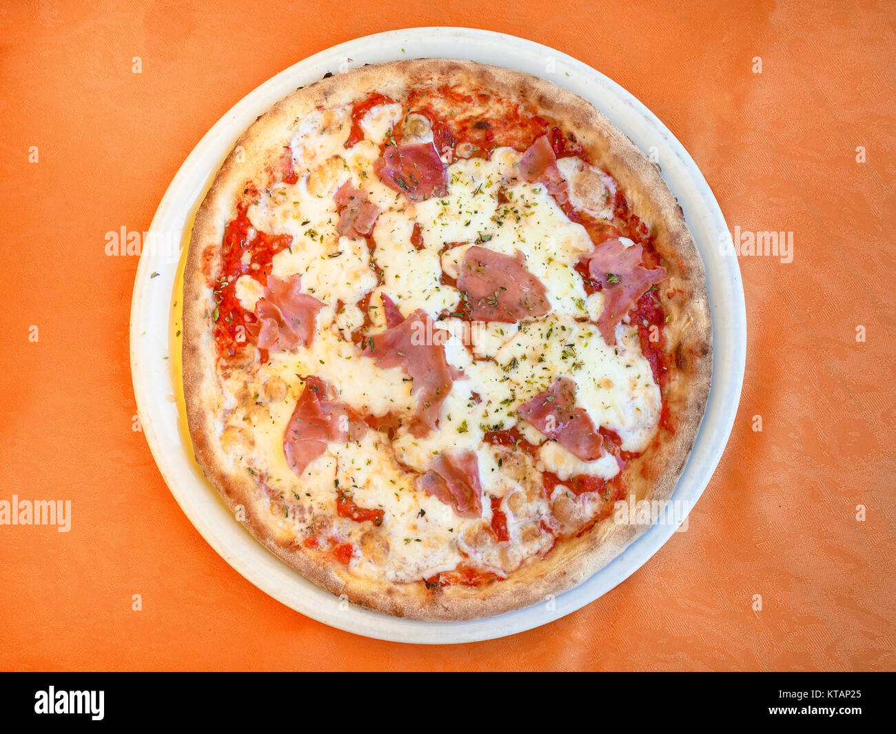 above view of pizza with prosciutto on plate Stock Photo