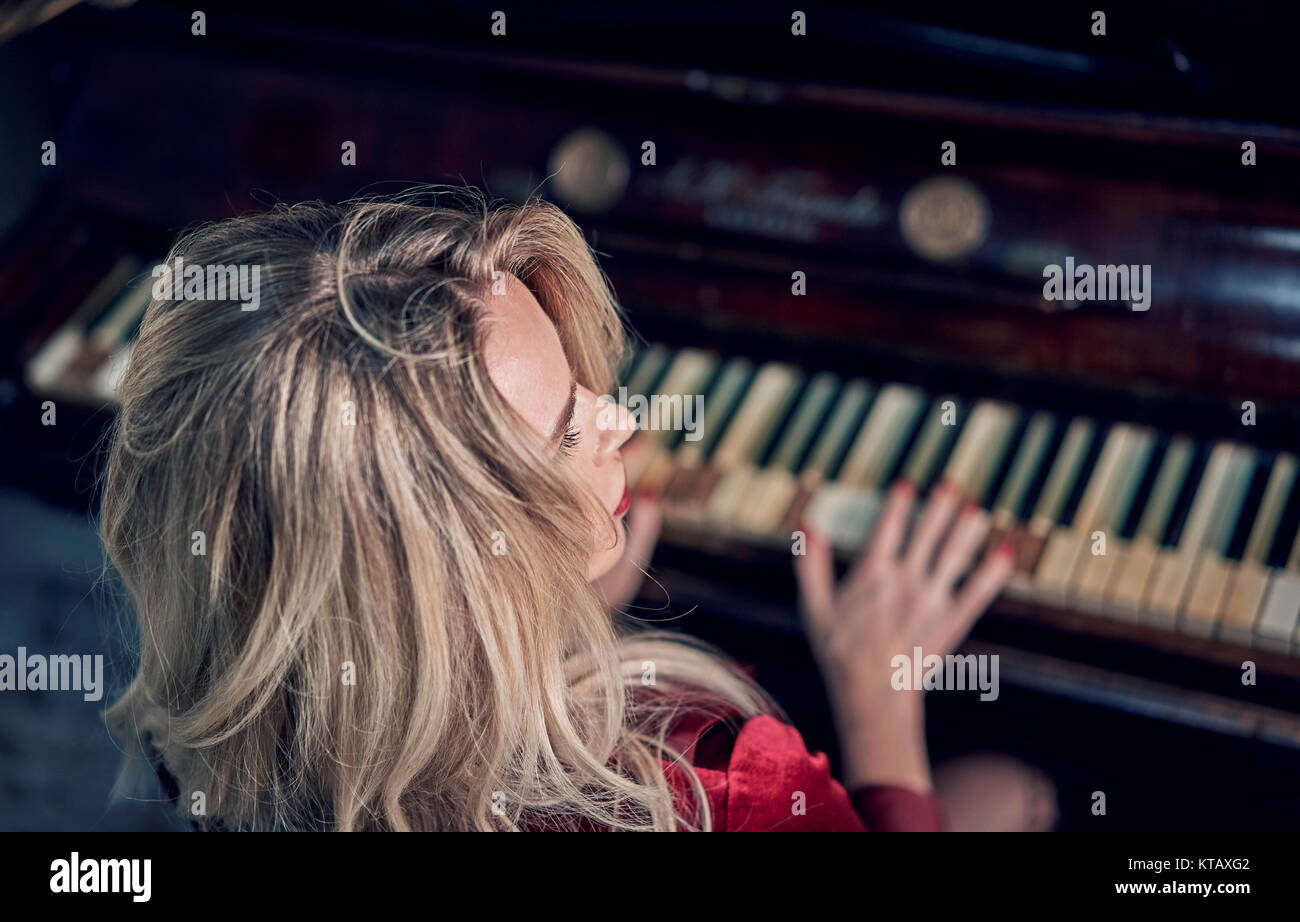 girl in the red dress playing the piano Stock Photo - Alamy