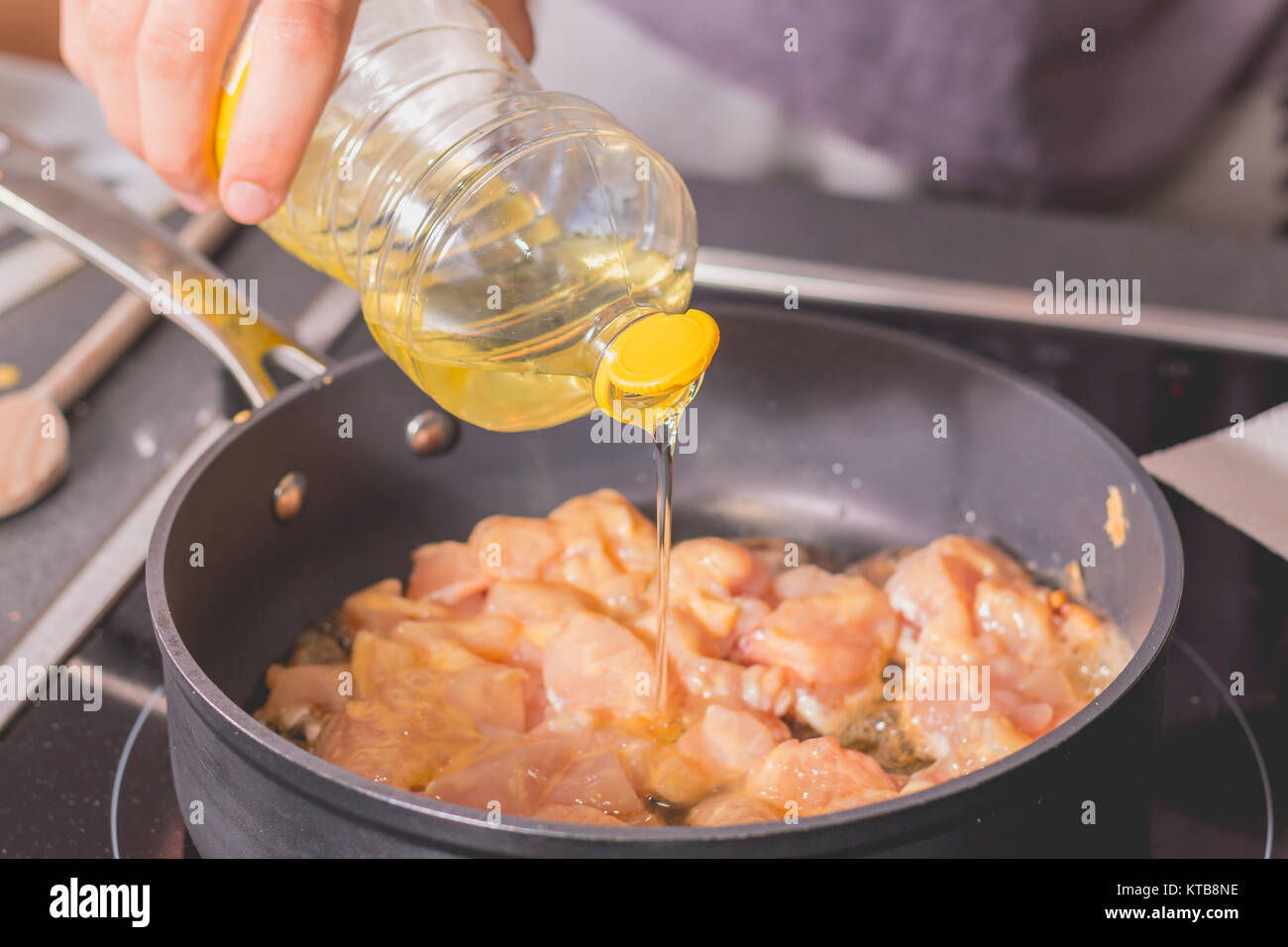 Cook pouring oil into a hot saucepan Stock Photo Alamy