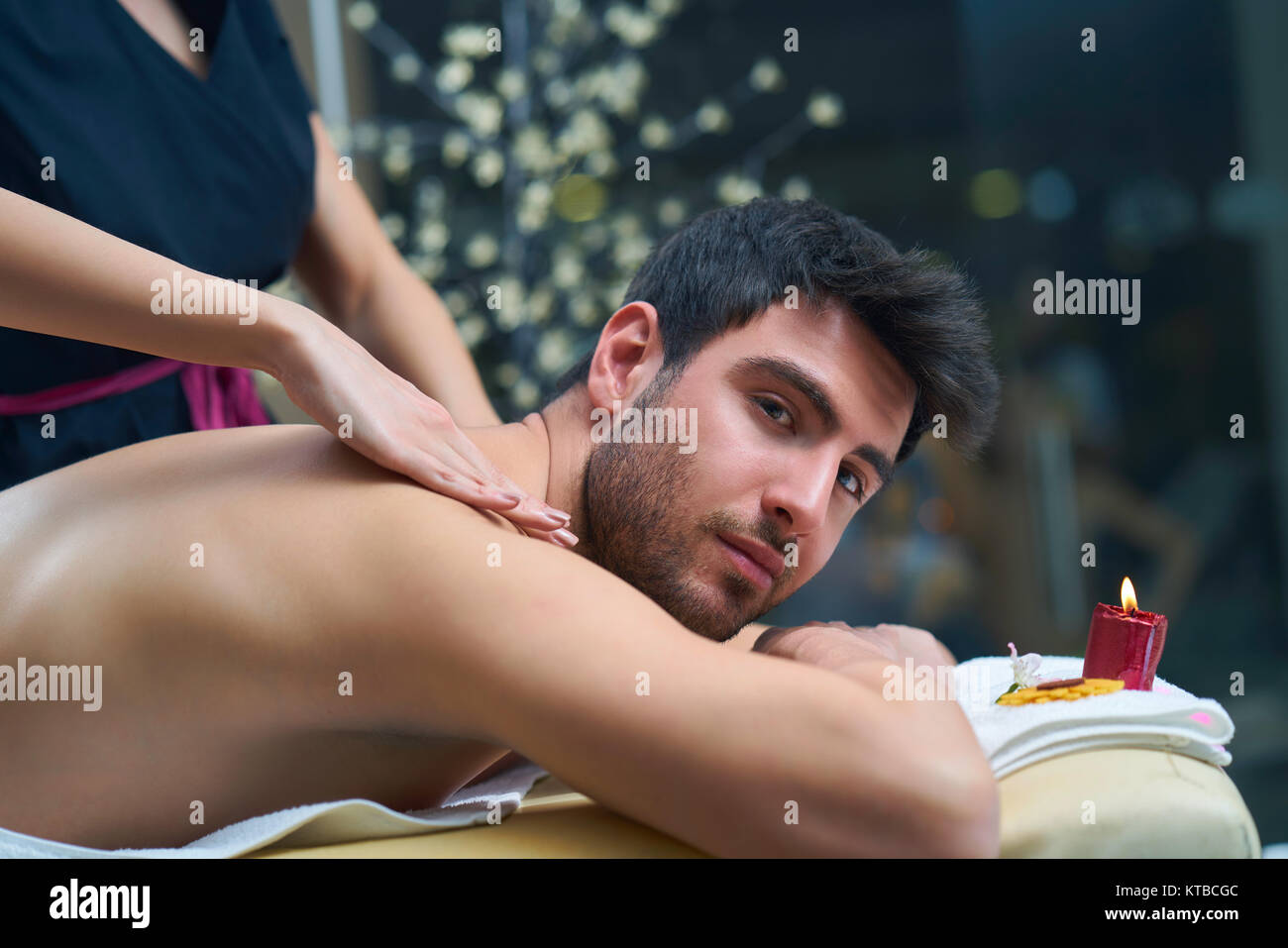 Sports massage. Massage therapist massaging shoulders of a male athlete, working with Trapezius muscle. Toned image Stock Photo