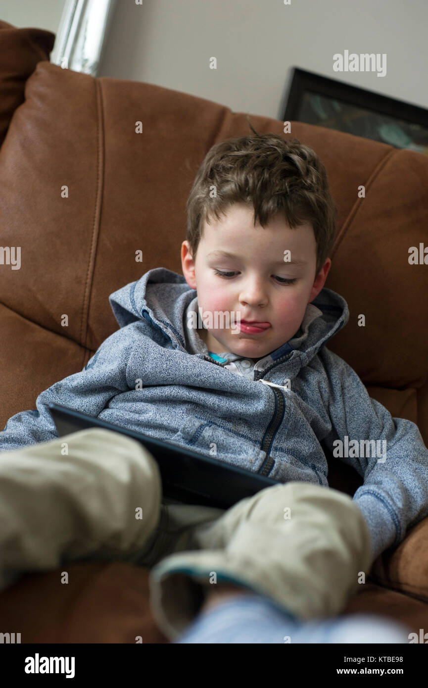 Young boy five year old playing games on a tablet Stock Photo Alamy