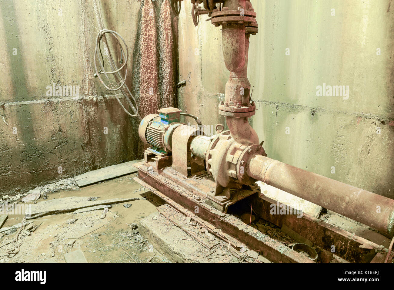 Old rusty pump in the basement. Basement of a water pumping stat Stock