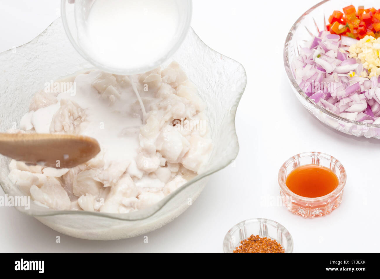 Add coconut milk to the marinated fish Stock Photo Alamy