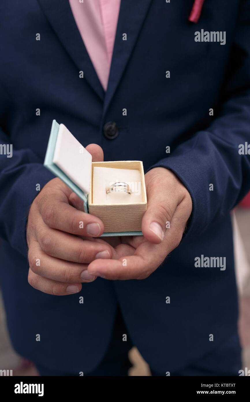 male hands holding a box with a wedding ring Stock Photo